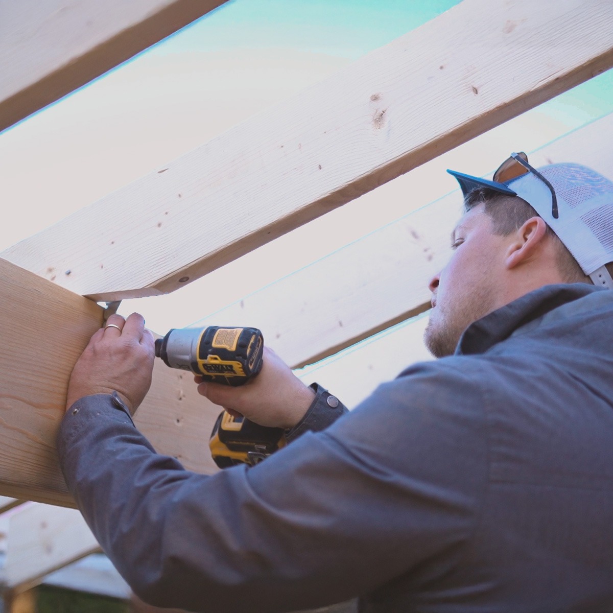 Keith Groen drills a screw into lumber in a roof.